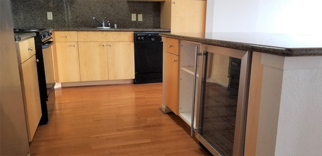 kitchen with decorative backsplash, light brown cabinetry, light hardwood / wood-style flooring, dishwasher, and range