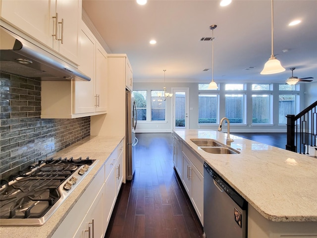 kitchen featuring stainless steel appliances, sink, decorative light fixtures, white cabinetry, and an island with sink