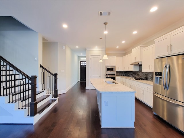 kitchen with light stone countertops, white cabinetry, and appliances with stainless steel finishes