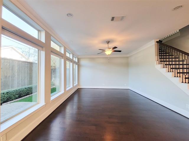 interior space featuring ceiling fan, ornamental molding, and dark wood-type flooring