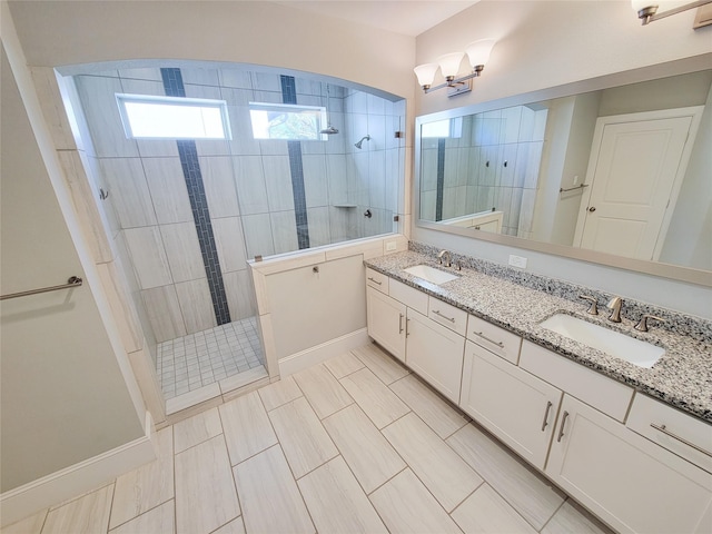 bathroom featuring a tile shower and vanity