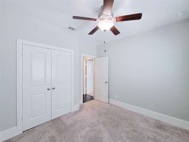 unfurnished bedroom featuring carpet, ceiling fan, and a closet