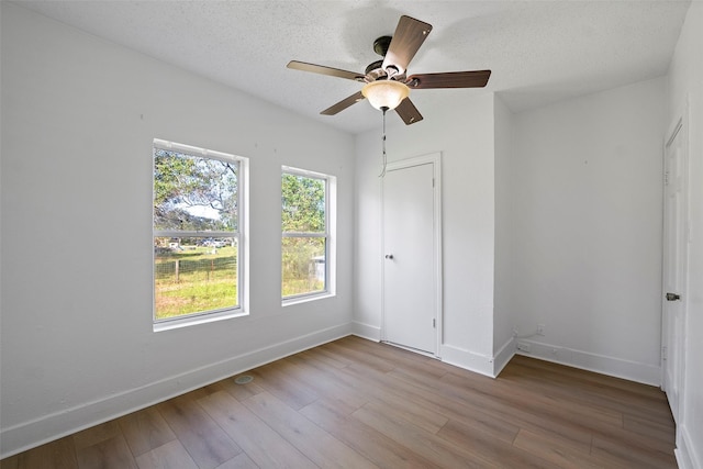 unfurnished bedroom with a textured ceiling, light hardwood / wood-style flooring, and ceiling fan