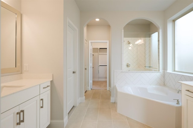 bathroom featuring plus walk in shower, vanity, and tile patterned floors