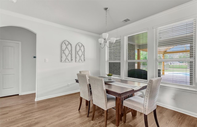 dining area featuring hardwood / wood-style floors, a chandelier, and ornamental molding