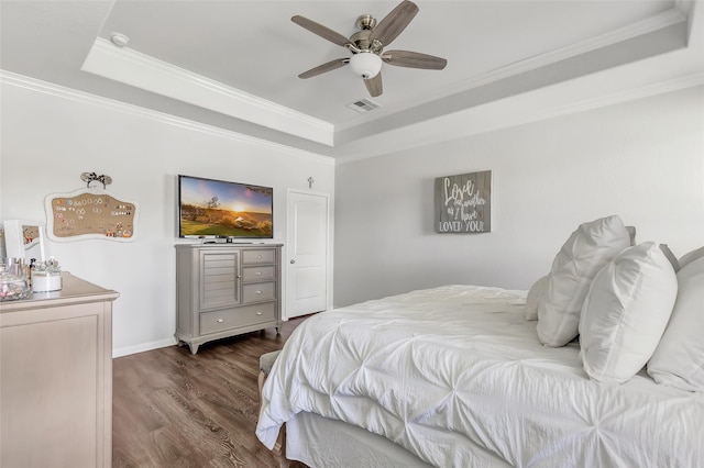 bedroom featuring a raised ceiling, ceiling fan, dark hardwood / wood-style flooring, and crown molding