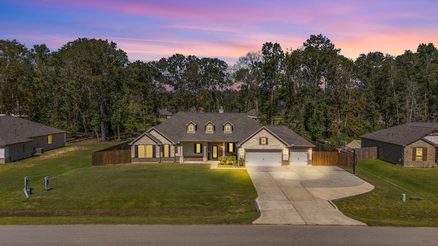 french country style house with a lawn and a garage