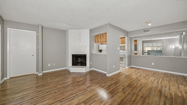 unfurnished living room featuring a textured ceiling, a fireplace, and hardwood / wood-style flooring