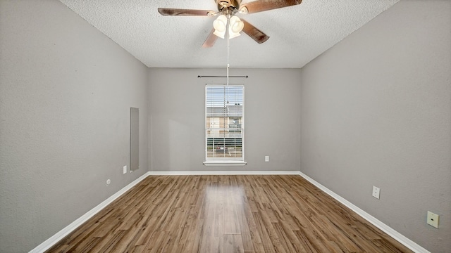 empty room with hardwood / wood-style floors, a textured ceiling, and ceiling fan