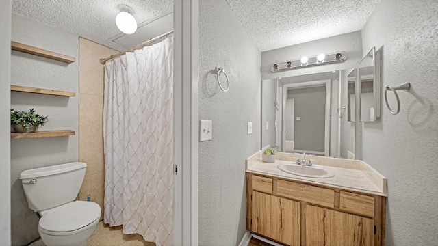 bathroom featuring vanity, a textured ceiling, and toilet