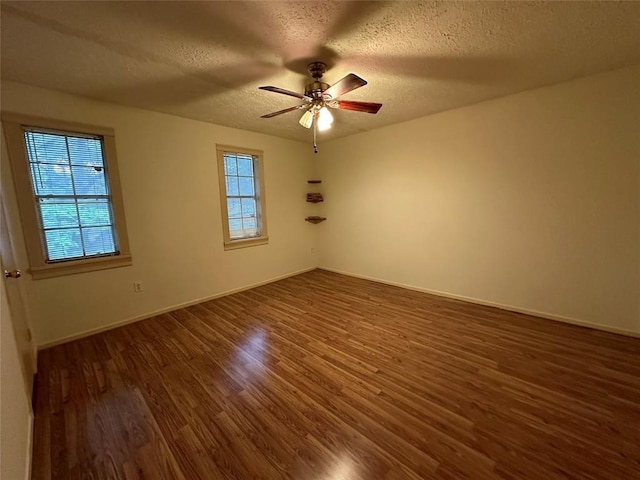 empty room featuring a textured ceiling, ceiling fan, and dark hardwood / wood-style floors