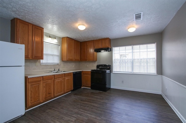 kitchen with dark hardwood / wood-style flooring, sink, black appliances, and a textured ceiling