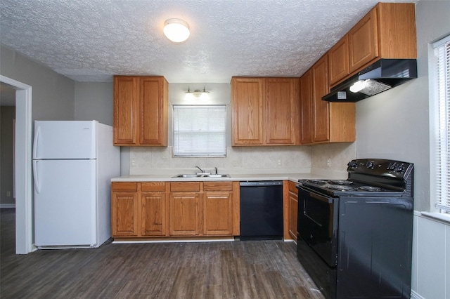 kitchen with a textured ceiling, sink, dark wood-type flooring, and black appliances