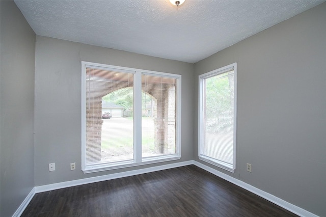 unfurnished room featuring a textured ceiling and dark wood-type flooring