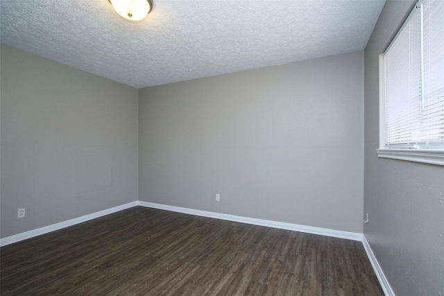 unfurnished room featuring dark hardwood / wood-style flooring and a textured ceiling