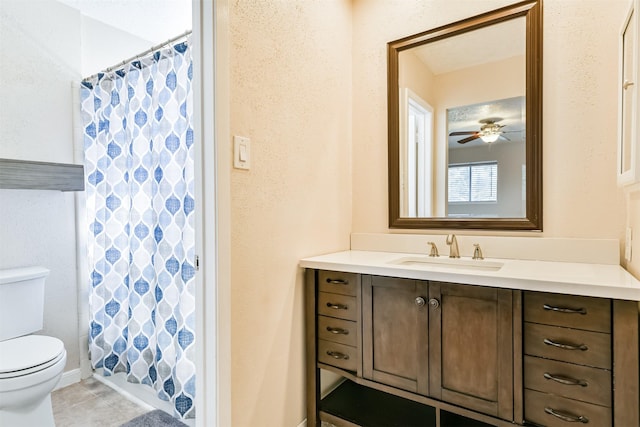 bathroom featuring curtained shower, ceiling fan, vanity, and toilet