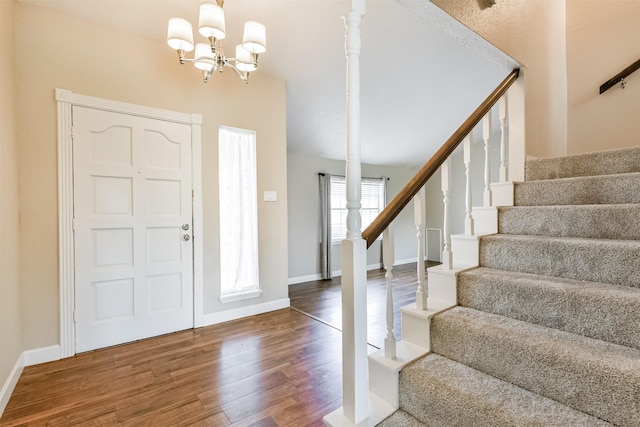 entryway featuring dark hardwood / wood-style flooring and an inviting chandelier