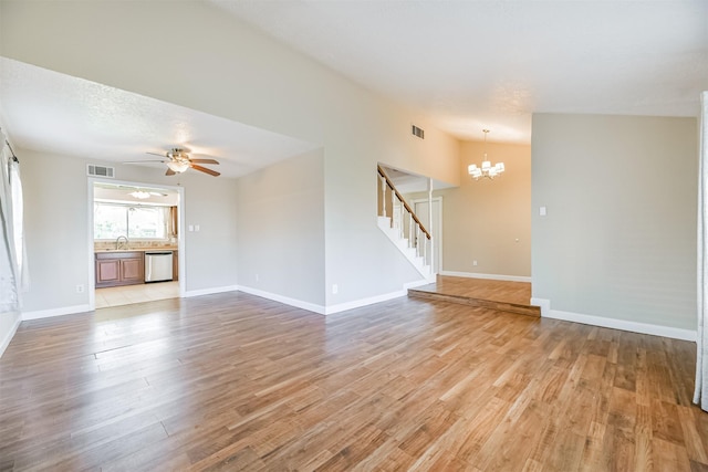 unfurnished living room featuring ceiling fan with notable chandelier, light wood-type flooring, sink, and vaulted ceiling