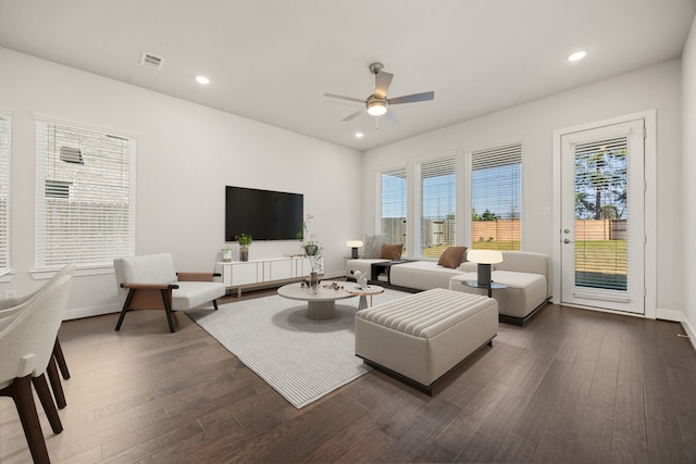 living room with ceiling fan and dark wood-type flooring