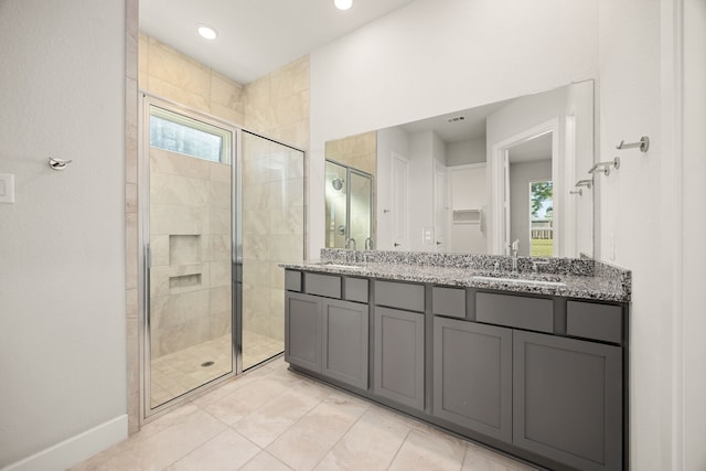 bathroom with tile patterned flooring, vanity, and walk in shower