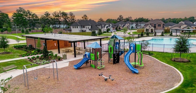 playground at dusk with a community pool and a lawn