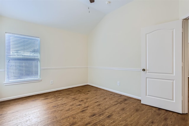 unfurnished room featuring lofted ceiling, plenty of natural light, and dark hardwood / wood-style flooring