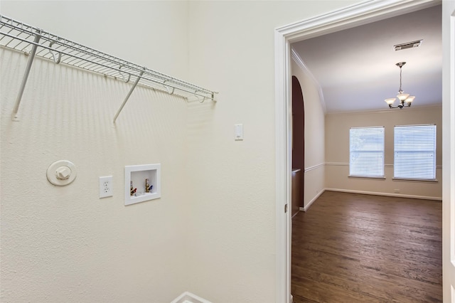 clothes washing area featuring washer hookup, crown molding, dark wood-type flooring, and a chandelier