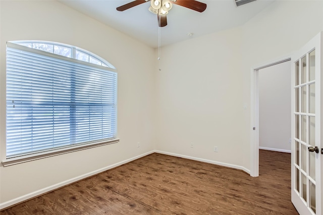 spare room featuring dark wood-type flooring, ceiling fan, and french doors