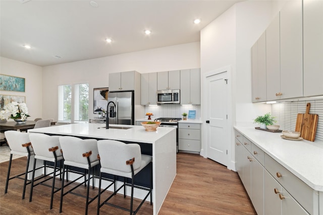 kitchen featuring a breakfast bar, a center island with sink, and stainless steel appliances