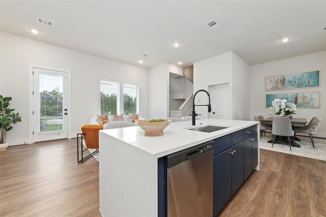 kitchen featuring dishwasher, an island with sink, hardwood / wood-style floors, and sink