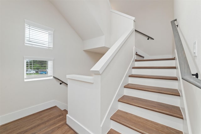 staircase with hardwood / wood-style flooring and vaulted ceiling