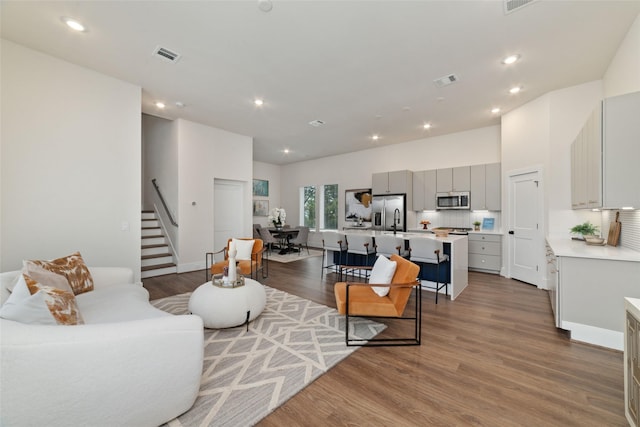 living room featuring hardwood / wood-style flooring and sink