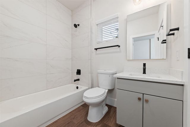 full bathroom with hardwood / wood-style flooring, vanity, toilet, and tiled shower / bath