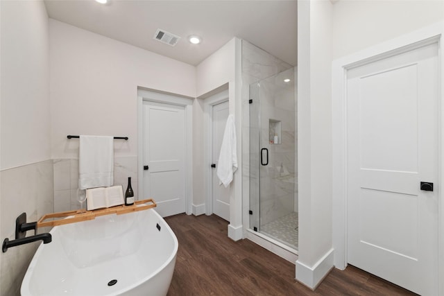 bathroom with hardwood / wood-style flooring, independent shower and bath, and sink