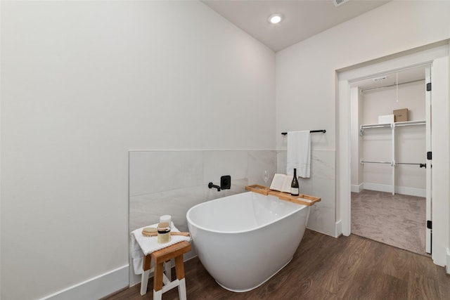 bathroom featuring wood-type flooring and a tub