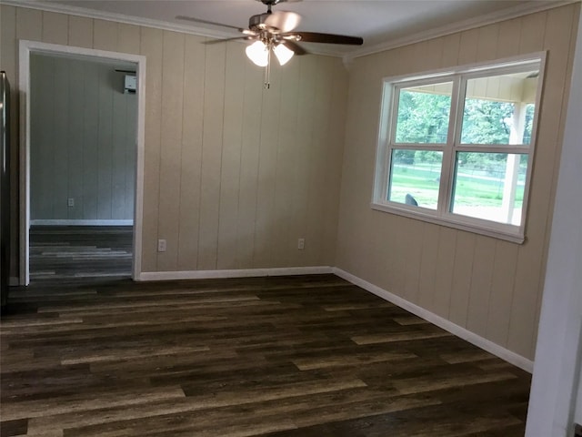 unfurnished room with ceiling fan, dark wood-type flooring, wood walls, and ornamental molding