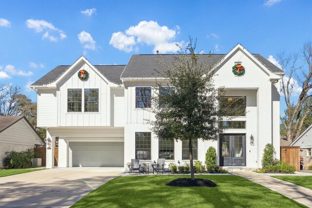 view of front facade with central AC unit, a garage, a front lawn, and french doors