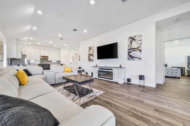 living room with light wood-type flooring and a fireplace