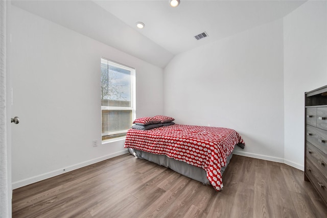 bedroom with lofted ceiling and wood-type flooring