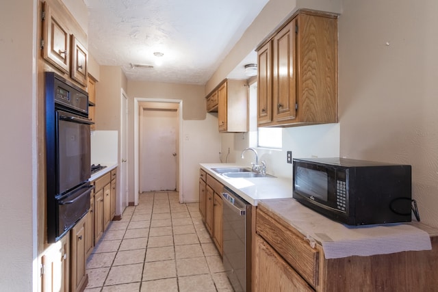 kitchen featuring light tile patterned floors, sink, a textured ceiling, and black appliances