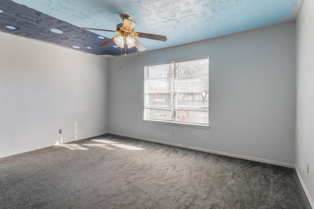 carpeted empty room featuring ceiling fan and a textured ceiling