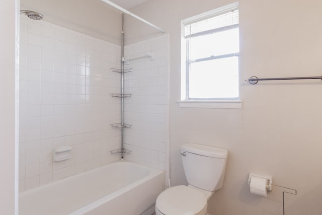 bathroom featuring toilet and tiled shower / bath