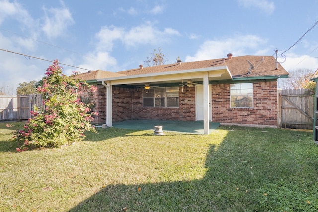 back of property featuring ceiling fan, a patio area, and a lawn