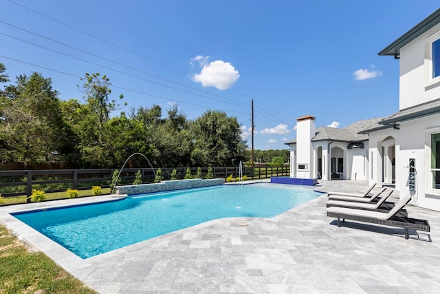 view of swimming pool featuring pool water feature and a patio