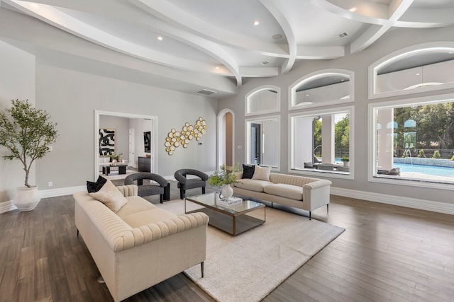 living room with beam ceiling and dark wood-type flooring