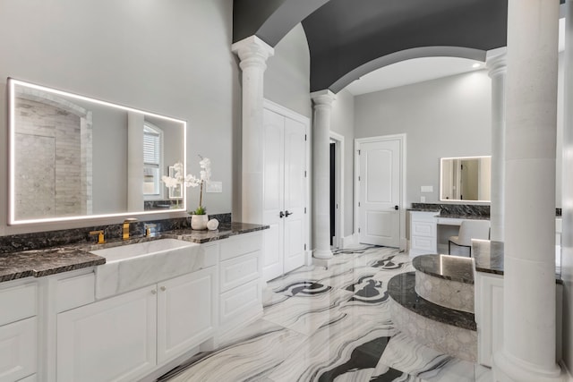 bathroom featuring vanity, a high ceiling, and decorative columns