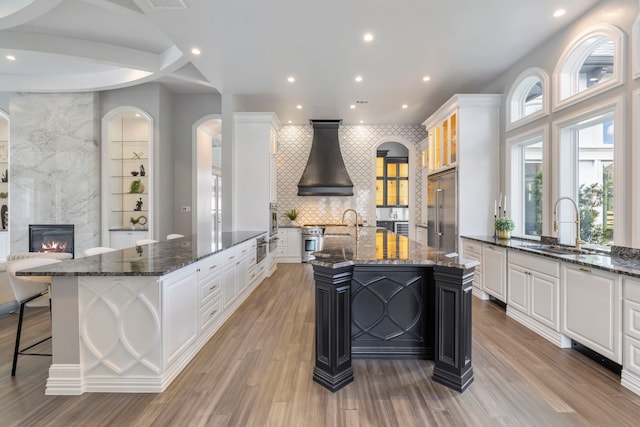 kitchen with stainless steel appliances, dark stone countertops, and a spacious island