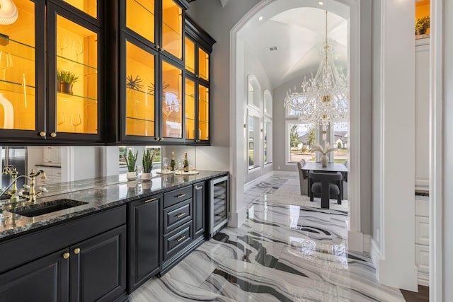 bar with wine cooler, sink, and dark stone counters