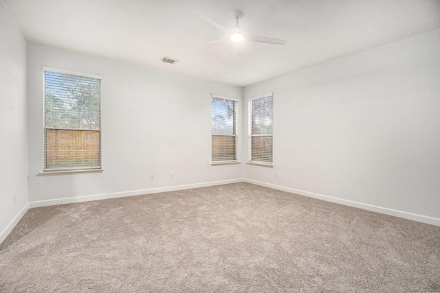 unfurnished room with ceiling fan, plenty of natural light, and carpet