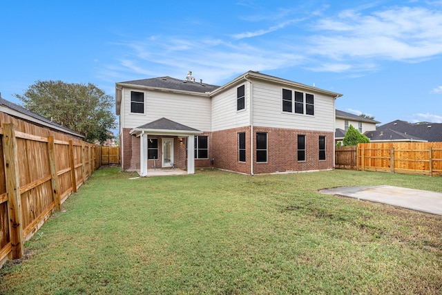 back of property with a yard and a patio area